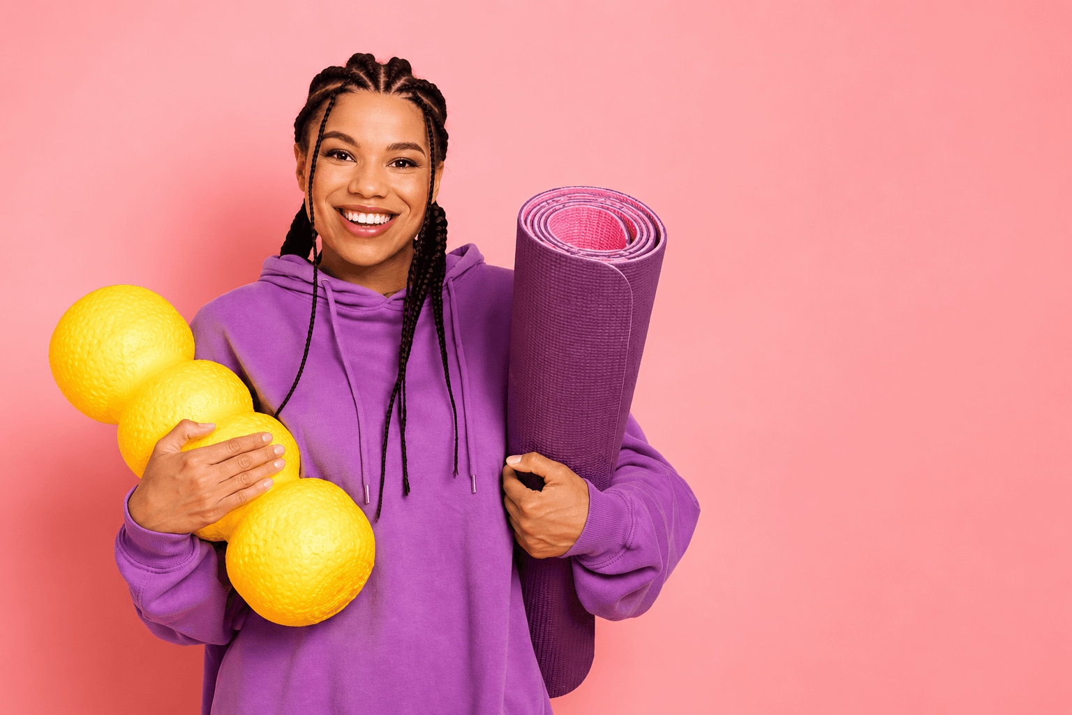 a woman holding pilates mat and equipment