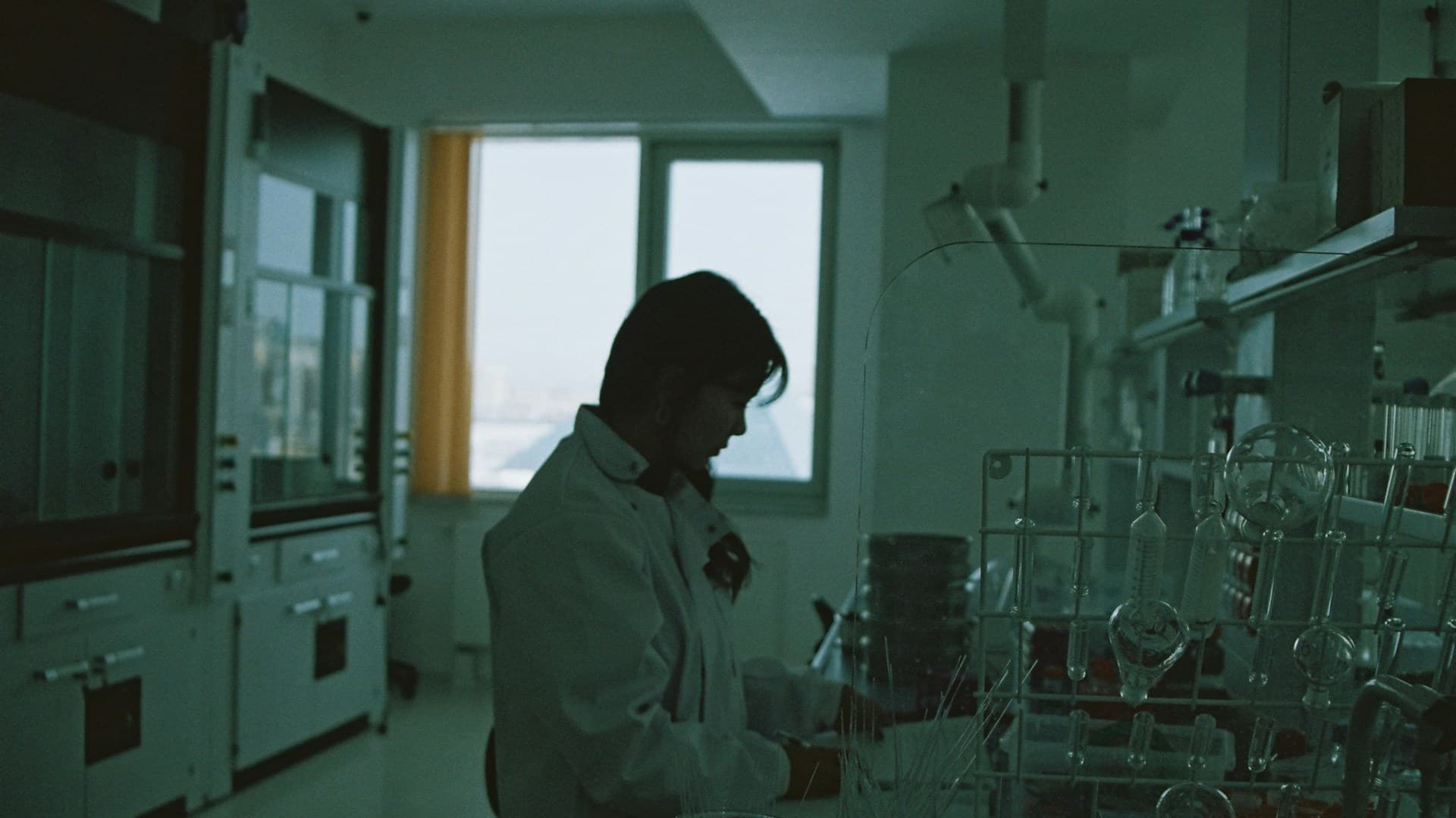 A scientist looking at a screen displaying a DNA helix, representing the scientific basis of biohacking.
