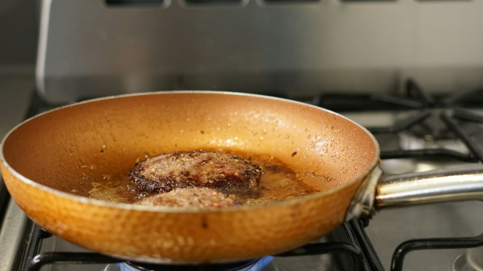 A person adding a generous pat of butter to a pan, highlighting the importance of animal fats in a carnivore meal plan.