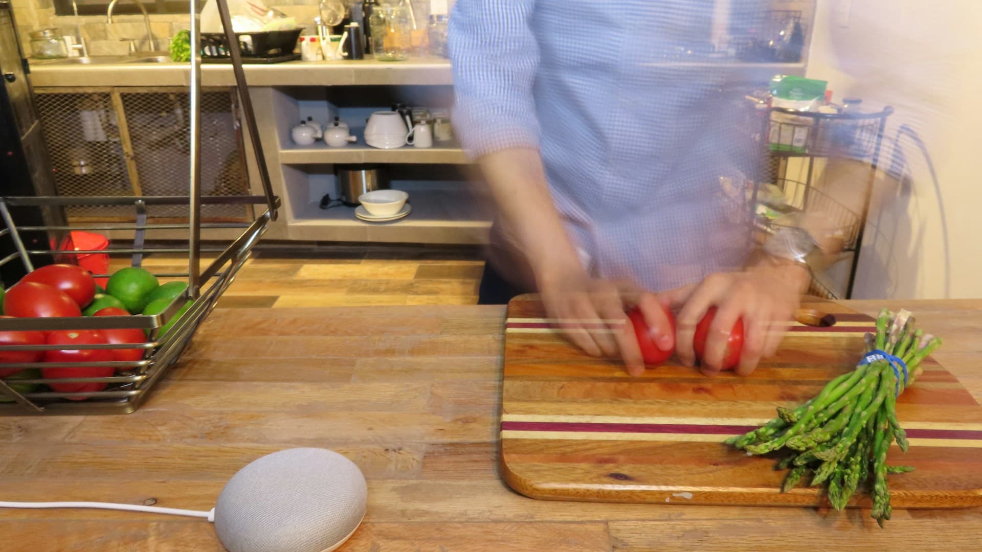 A chef's hands chopping a variety of fresh vegetables like bell peppers and zucchini on a wooden board.