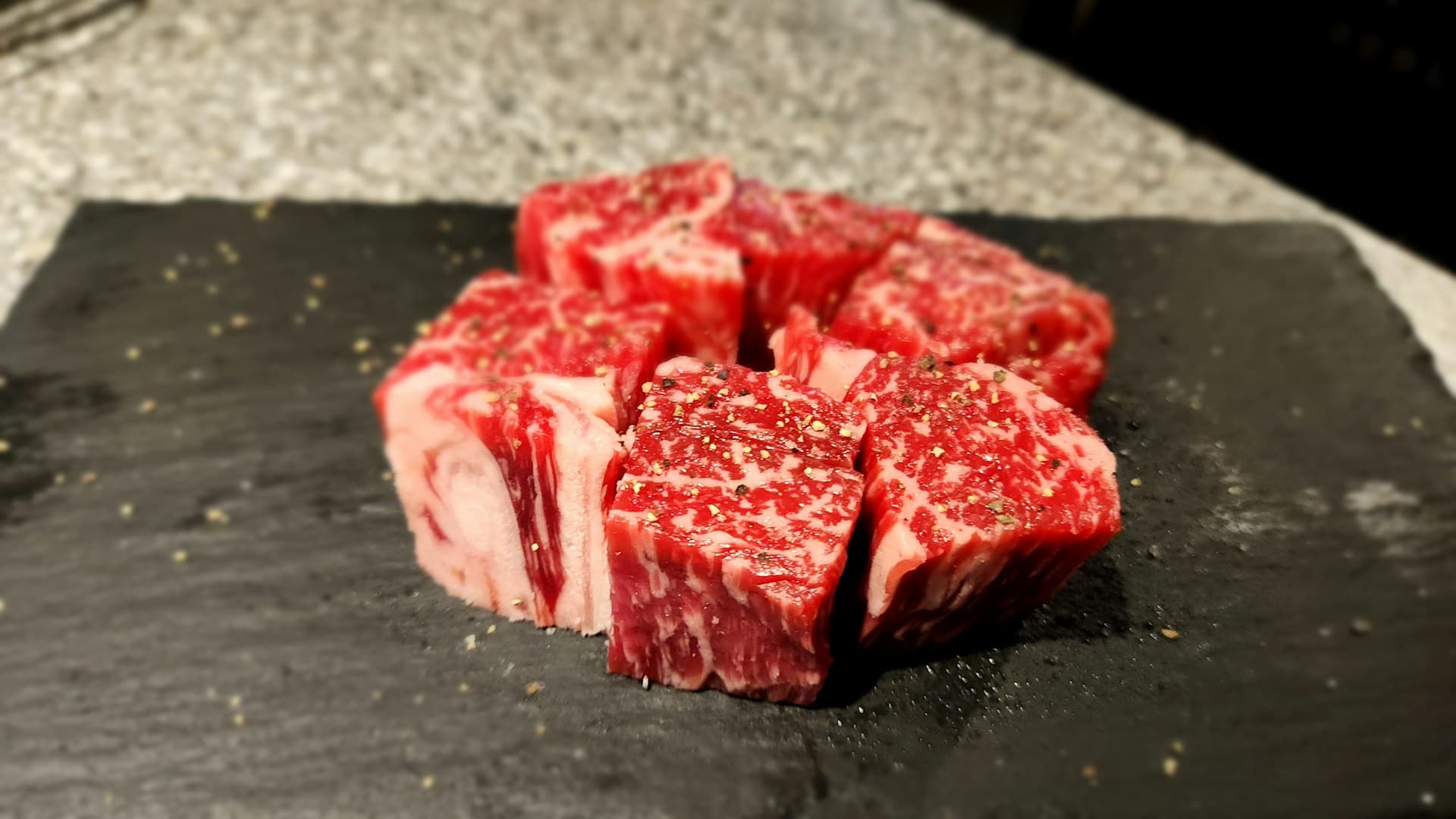 A close-up of a perfectly seared ribeye steak on a cutting board, sliced to show its medium-rare interior.
