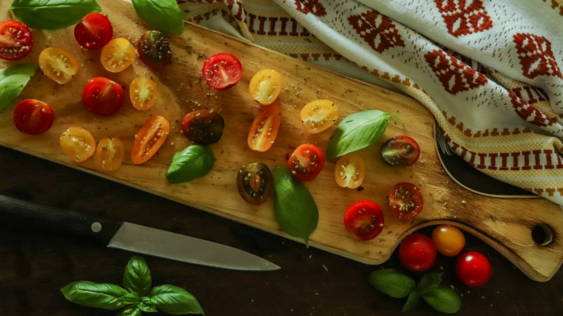 A colourful spread of fresh ingredients for Mediterranean tacos, including chicken, chickpeas, tomatoes, cucumbers, and pita bread.