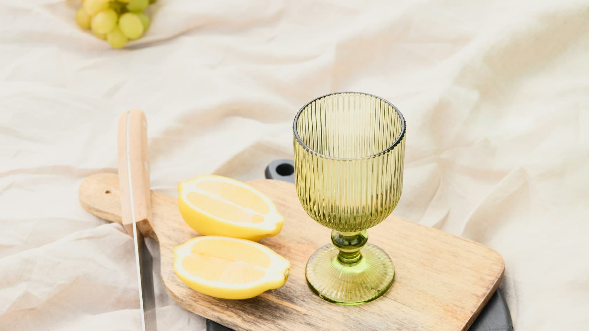 A glass of water with a slice of lemon on a wooden table, symbolizing hydration during dietary changes.