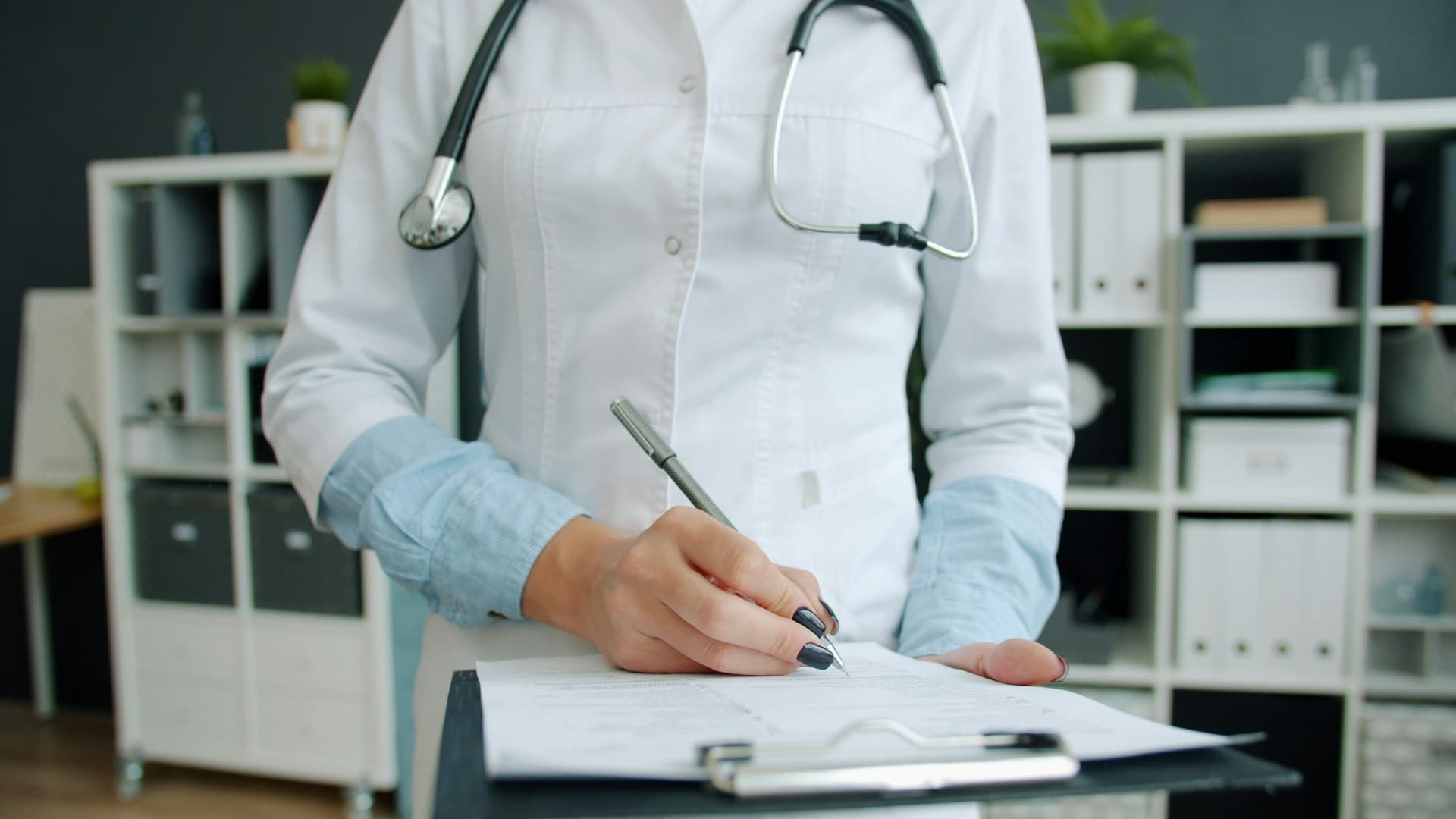 A healthcare professional in a white coat looking at a tablet, symbolizing when to seek medical advice.