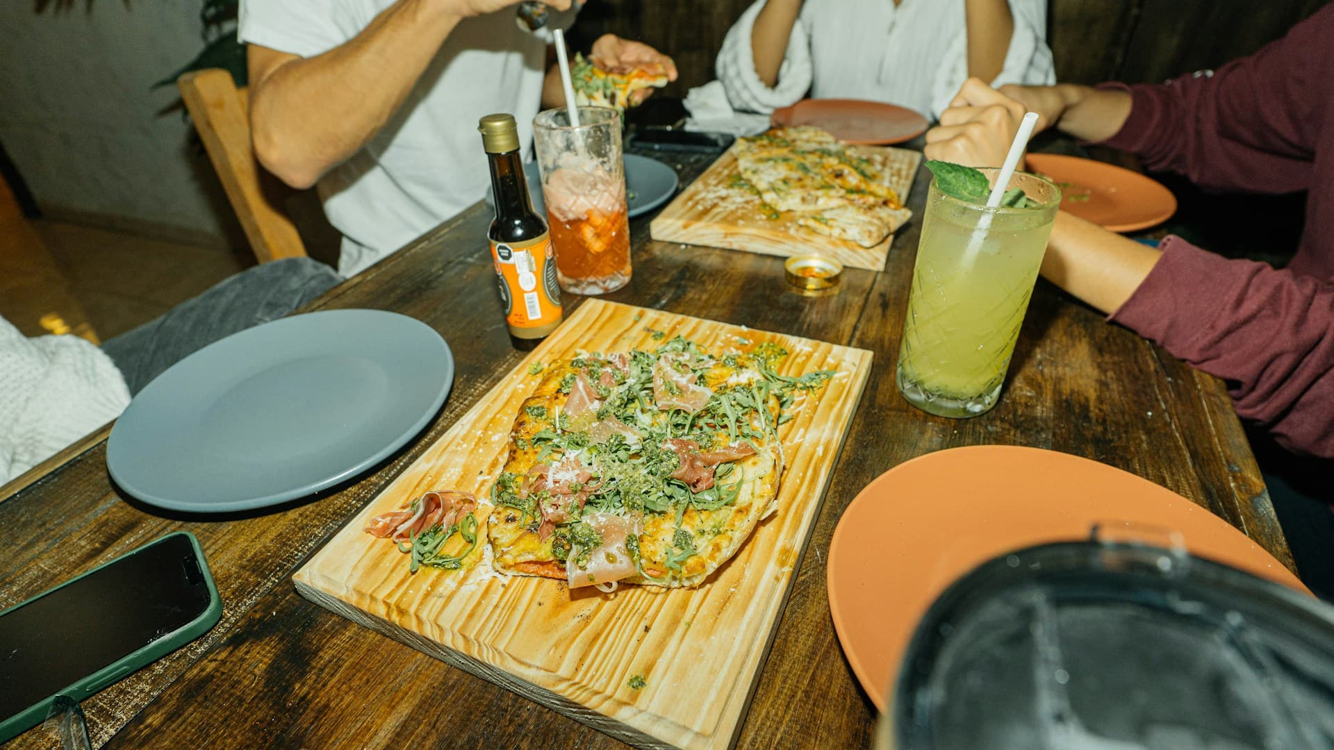 A person looking at two different plates of food, one representing the Paleo diet with meat and vegetables, the other representing the Mediterranean diet with fish, grains, and olive oil.
