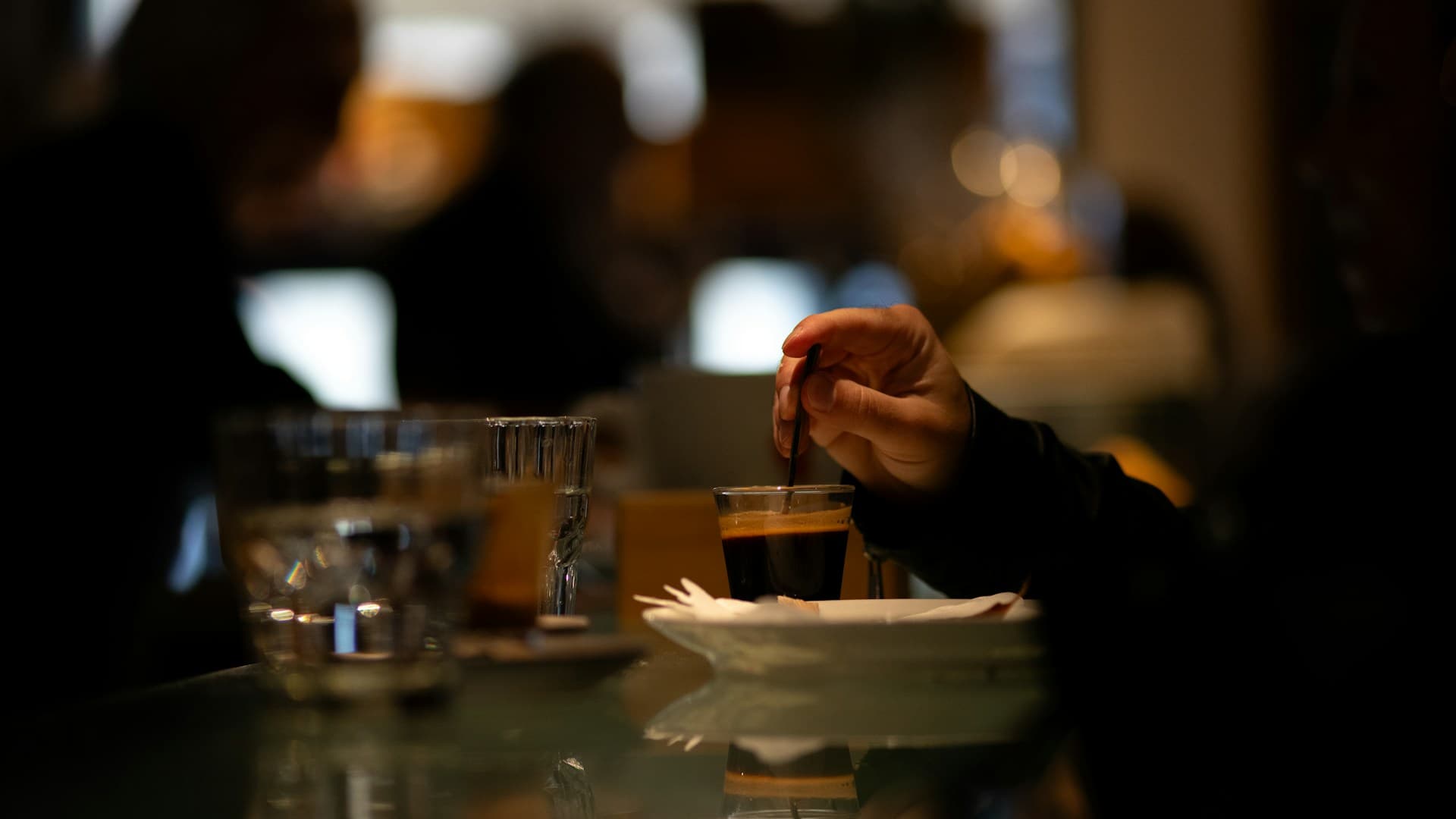 A person sitting at a table, mindfully eating a small portion of a healthy dessert, fully focused on the experience.