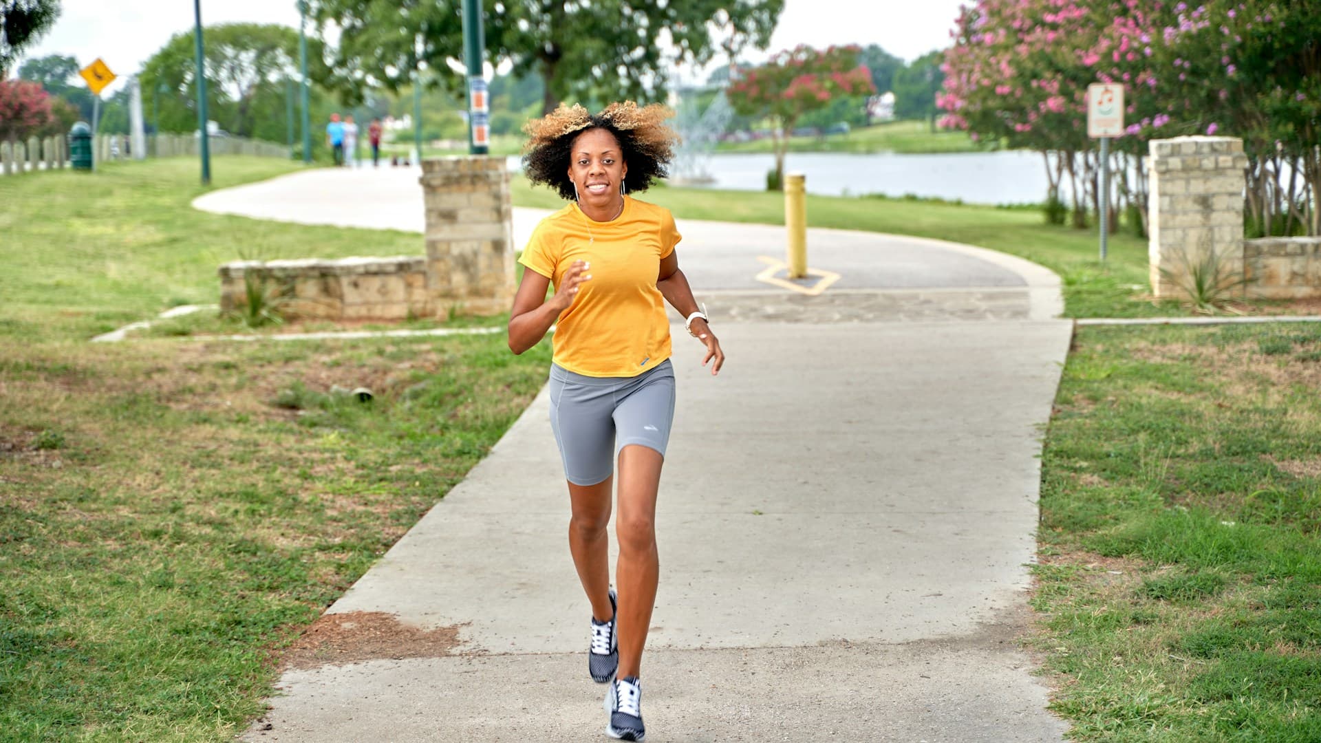 A smiling, healthy person jogging along a sunny path, conveying energy and vitality from a healthy diet.