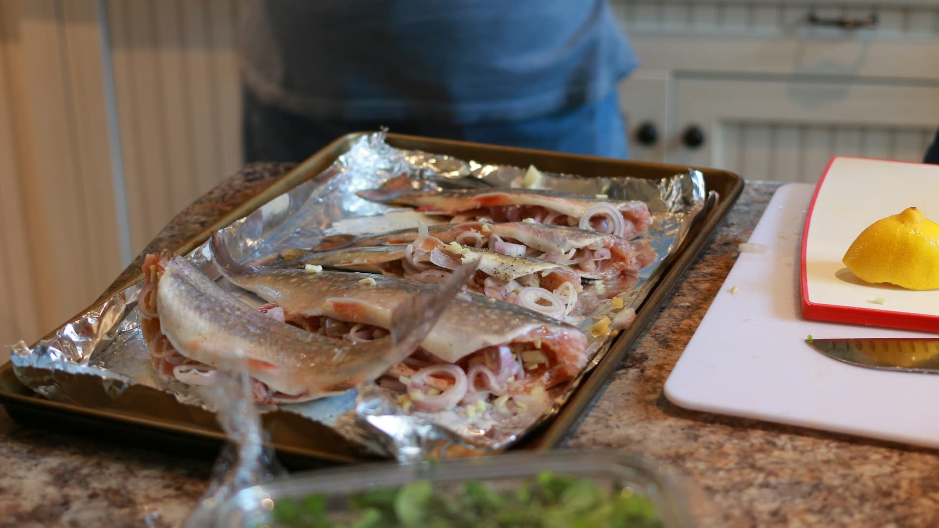 A top-down view of a carnivore pizza with a meat crust being prepared on a baking sheet with parchment paper.