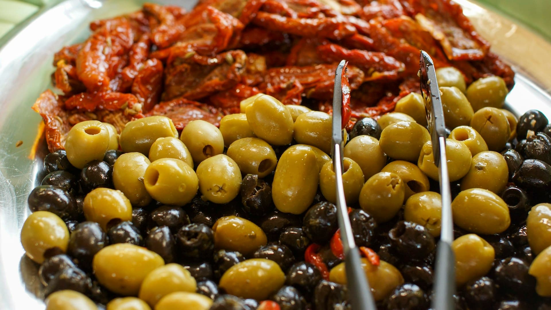 A vibrant, colourful plate of Mediterranean food, including grilled fish, fresh vegetables, olives, and a drizzle of olive oil.