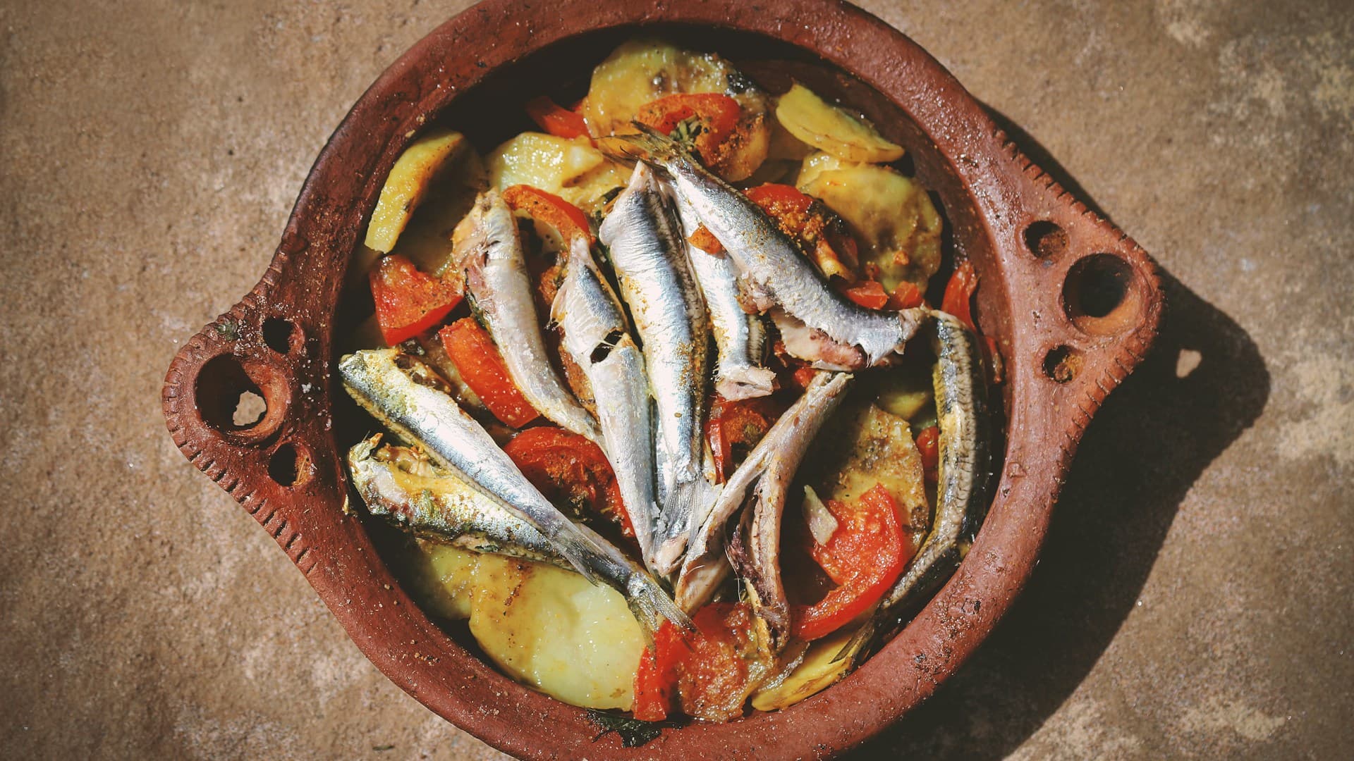 A vibrant split-image showing Mediterranean foods like fish and olive oil on one side, and Paleo foods like lean meat and vegetables on the other.